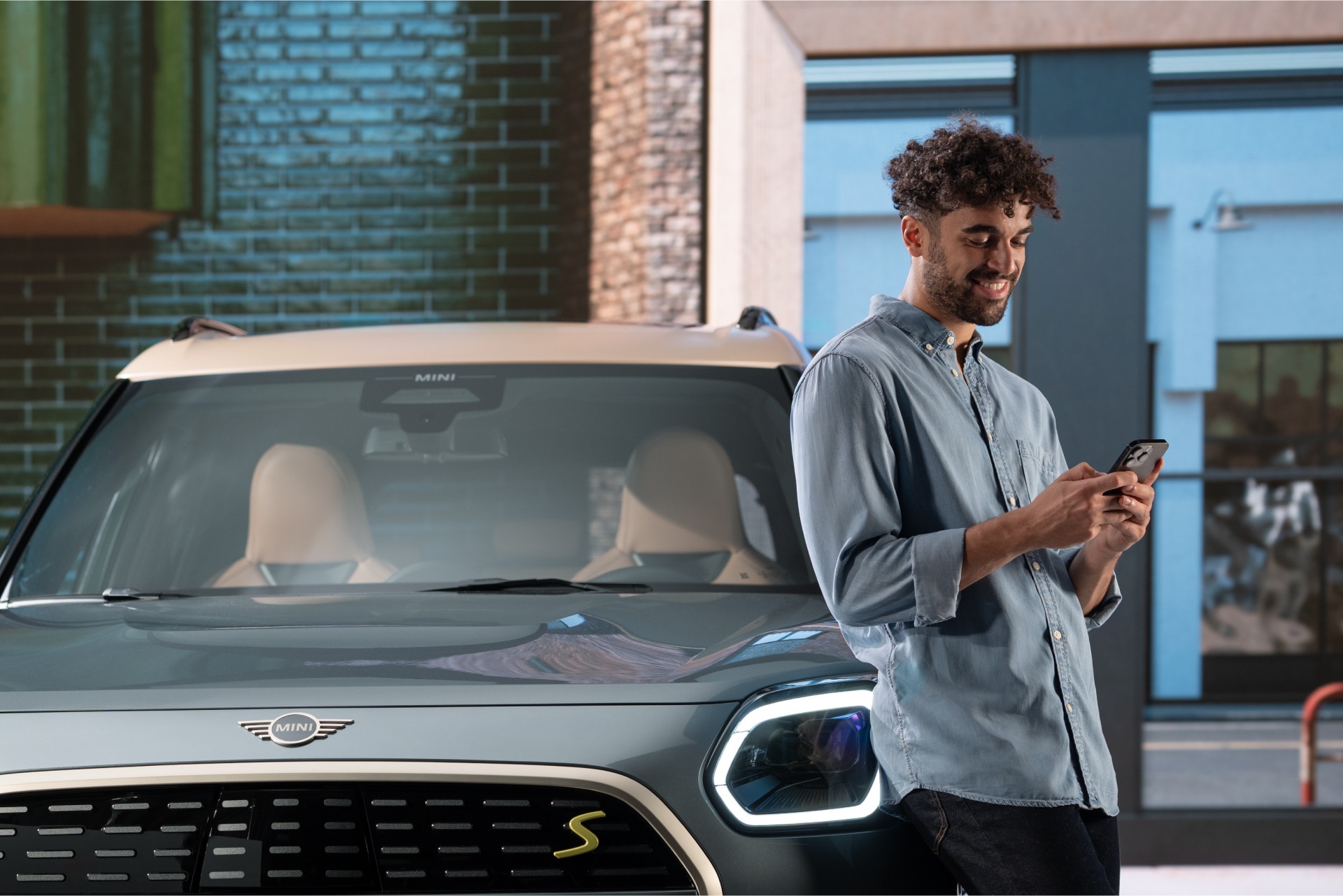 MINI vooraanzicht, detail, met man die tegen MINI leunt